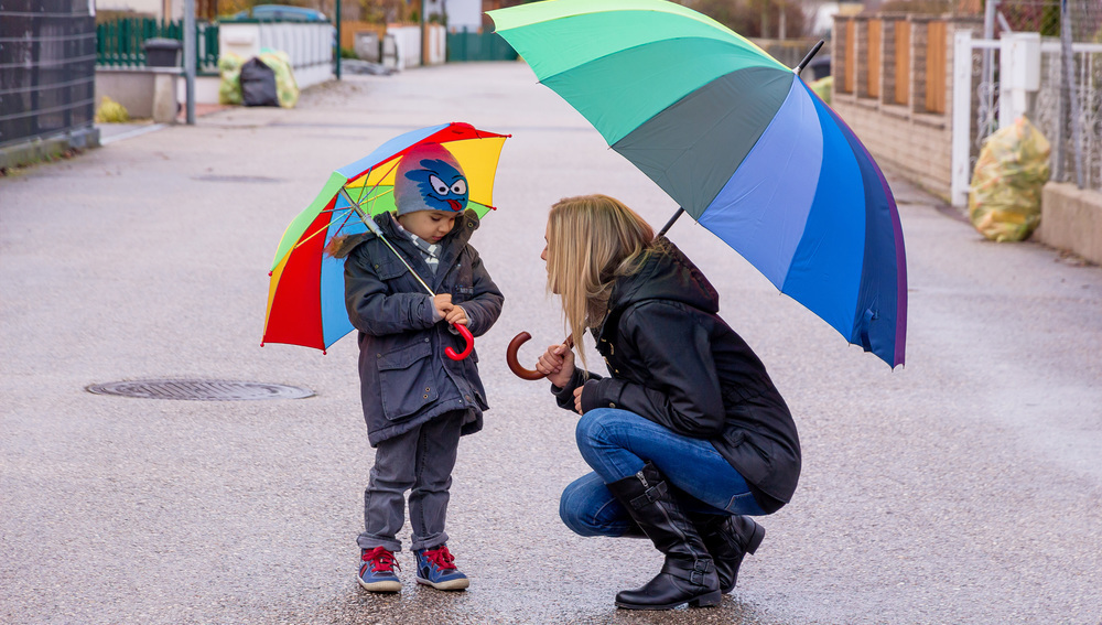 Frau und Kind mit Regenschirm