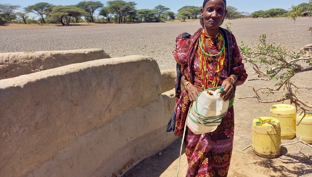 Kenia, Marsabit: Zehn Liter Trinkwasser kann Kame Gonche im Nomadendorf El Boru Magadho für ihre zehnköpfige Familie für einen Tag aus dem Brunnen schöpfen