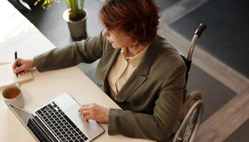 Frau am Rollstuhl bei der Arbeit