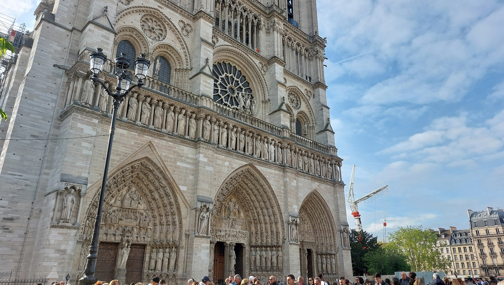 Westfassade der Kathedrale Notre-Dame de Paris mit Besucherschlange im APril 2025