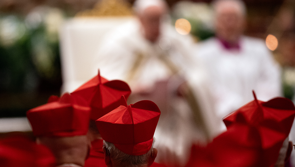 Kardinäle mit Birett und Papst im Hintergrund